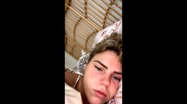Cute cat enjoys licking his owner's ear while relaxing in bed