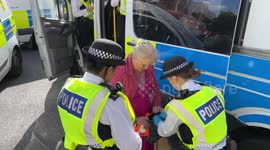 Just Stop Oil activists block the junction of Marylebone Road and Baker Street in London. The police are arresting the protesters. The protesters have their hands stuck with glue.