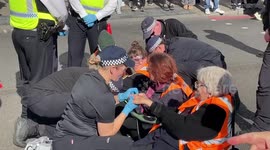 Just Stop Oil activists block the junction of Marylebone Road and Baker Street in London. The police are arresting the protesters. The protesters have their hands stuck with glue. Police remove glue from their hands.