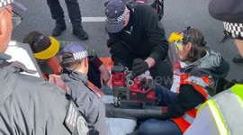 Climate Protest. Just Stop Oil activists block the junction of Marylebone Road and Baker Street in London. The police are arresting the protesters. The protesters have their hands stuck with glue.  Police remove glue from their hands. Police are using a d