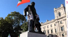 Iranians climb statue of Winston Churchill during demonstration in London