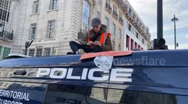 Just Stop Oil activist superglues himself to the top of a police van in Piccadilly Circus