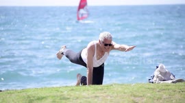 Elderly man doing yoga at the beach by the seashore