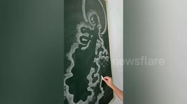Talented kindergarten teacher uses chalk to draw vivid pictures on blackboard