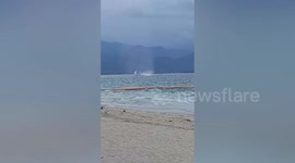 Nascent waterspout twists next to sailboat off tourist island in the Philippines