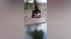 Playful girls ride backhoe's bucket as alternative to Ferris wheel in mountain village in the Philippines