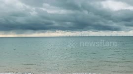 A Brighton Paddleboard paddles with his dog on the board on a stormy October day