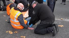 Just Stop Oil glue their hands to the road in front of New Scotland Yard before police removal team release them