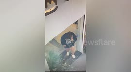 Woman frightened as glass shatters as she walks through doorway in China