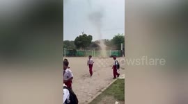 Pupils flee from enormous dust devil that formed in school grounds in Indonesia