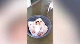 Infant sleeps peacefully in basin floating amid heavy monsoon floods in the Philippines