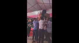 Pothead! Woman balances ceramic container and a man on her skull