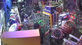 Staff hold onto glass cases in shop during Philippines earthquake
