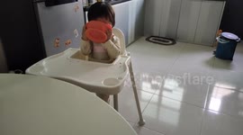 Funny toddler covers her face with baby bowl