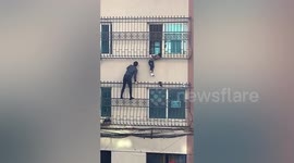Man climbs three floors to rescue boy hanging from window in China