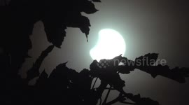 Sky darkened as moon blocks out section of the sun during solar eclipse