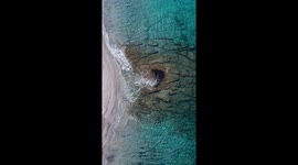 Top down video in lefkada island , Greece showing the sea coming to the beach