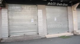 Palestinians walk past closed shops during a general strike in Gaza city following the killing of six Palestinians by Israeli forces during a raid in Nablus