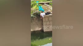 Kind-hearted man spends over an hour rescuing dog trapped on narrow riverbank