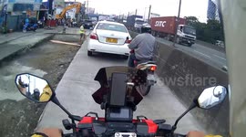 Bungling motorist gets stuck in wet concrete when he drives through newly-paved road in the Philippines