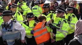 Police arrest and carry away Just Stop Oil protesters from Piccadilly in Westminster, London