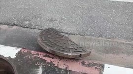 Manhole cover explodes sending debris crashing onto parked cars