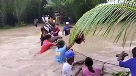 Villagers cross surging flood as Typhoon Nalgae batters the Philippines leaving 31 dead