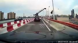 Camera crane crashes into light poles as vehicle drives along road in China