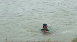 Man uses plastic bottle to swim across storm-swollen river after the collapse of bridge in Pangasinan, Philippines