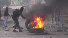 Palestinian protesters burn tires and hurl stones at Israeli forces during clashes in the West Bank city of Hebron