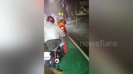 Riders stuck on road amid flying roofs and heavy rain during Typhoon Nalgae in the Philippines