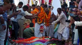 Priests walk over women lying on floor to bless them during Indian ritual