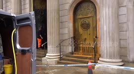 The Bank of England is cleaned up of orange paint as Paparazzi Dogs watch from the Royal Exchange