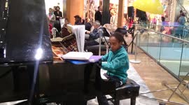 child plays stunning classical piece in crowded shopping centre