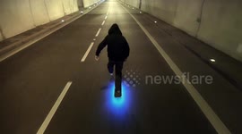 Drone films shows man skateboarding at night with glow-in-the-dark board
