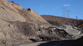 Worker inspects landslide buckled road in California V19284