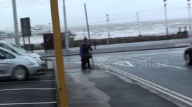 Elderly man and woman battle against strong Storm Clodagh winds