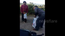 Granddad carries granddaughter in a sack to school bus stop