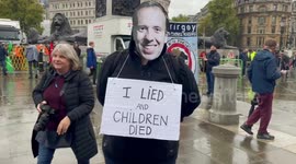 Protester wears Matt Hancock mask during anti-austerity protest in London