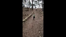 Kids running down hill in woods