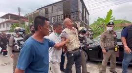 Crazed German biker, 47, lights fire and climbs on roof during clash with police in Thailand