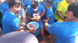 Competetive worker smashes watermelon into partner’s mouth during fastest eating game