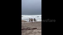 Surfers take advantage of rough waves whipped up by Hurricane Nicole
