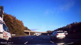 DASHCAM - Police Motorcyclist comes onto motorway and weaves back and forth across all four lanes, nearly hitting driver's car!
