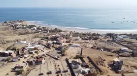 tropical north peru drone flying backwards up da hill faceing point break pacific ocean coast southern hemisphere with marina & pier in background sunny day blue waters small waves swell no audio mute
