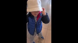 My son trying on a hat in H  & M and dancing to the music having a laugh.