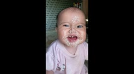 Cute baby girl's reaction to rice sticking to her face