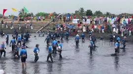 Locals wear fancy dress for mass fishing competition in pond in Thailand