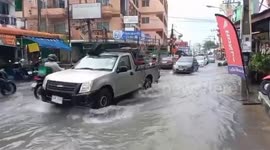 Cars drive through flooded roads following heavy rain in eastern Thailand