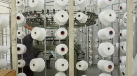 Palestinian laborers work inside a textile factory ahead of winter season